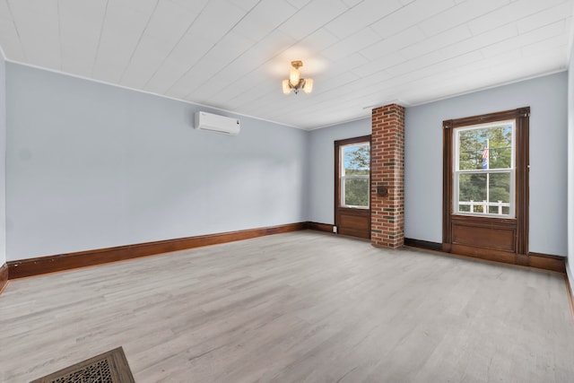 spare room featuring ornamental molding, light hardwood / wood-style flooring, ornate columns, and a wall unit AC