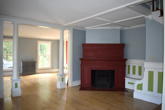 unfurnished living room with radiator heating unit, ornamental molding, coffered ceiling, and hardwood / wood-style floors