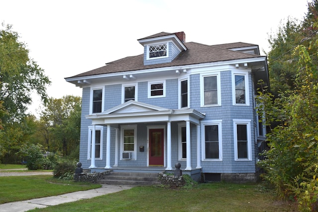 view of front of home with cooling unit, a porch, and a front lawn