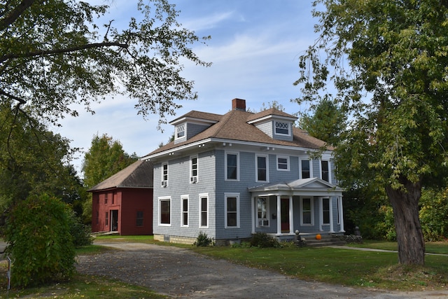 colonial-style house featuring a front lawn