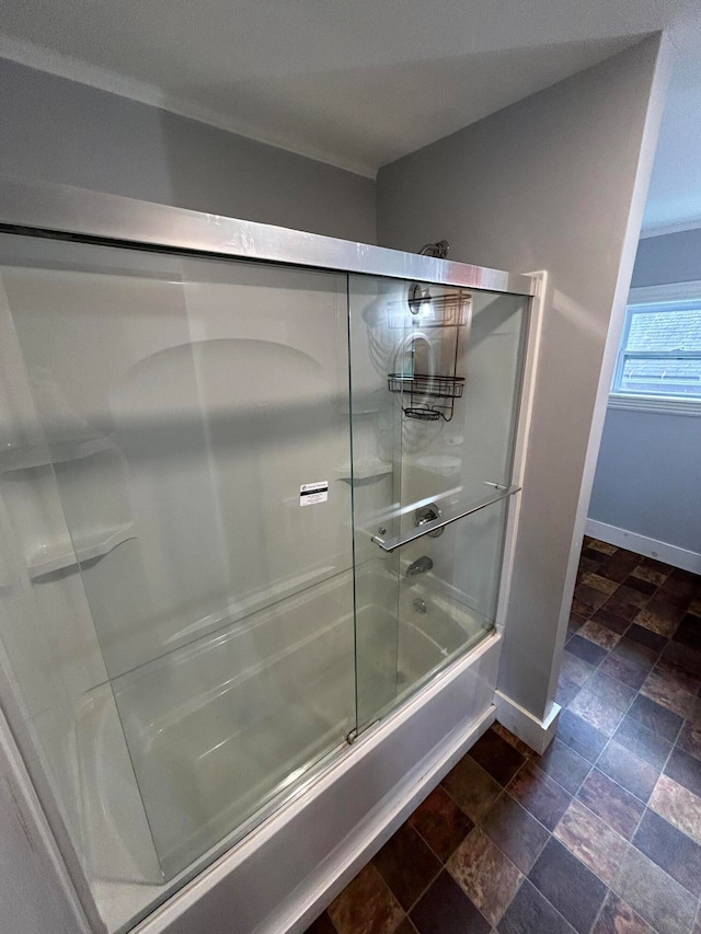 bathroom featuring combined bath / shower with glass door