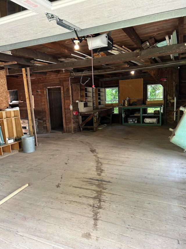 garage with a garage door opener and wood walls