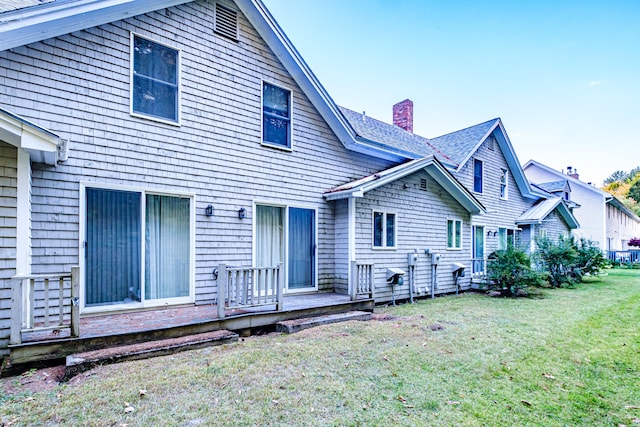 back of property featuring a deck and a yard