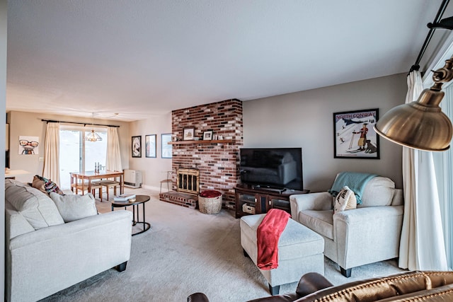 living room with a notable chandelier, carpet floors, and a fireplace