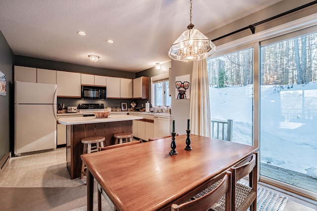 dining area with light colored carpet, an inviting chandelier, sink, and a textured ceiling