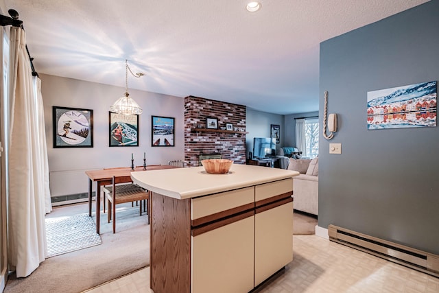 kitchen with a textured ceiling, hanging light fixtures, a kitchen island, and baseboard heating