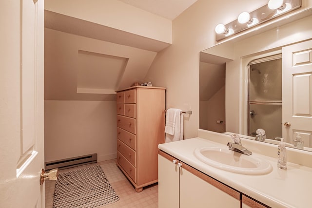 bathroom with vanity, baseboard heating, and vaulted ceiling