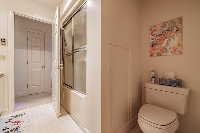 bathroom featuring enclosed tub / shower combo and toilet