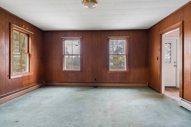 empty room featuring light carpet, a baseboard radiator, and wood walls