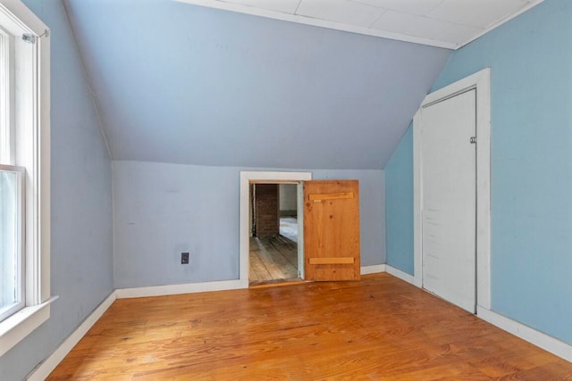 bonus room with lofted ceiling and hardwood / wood-style floors