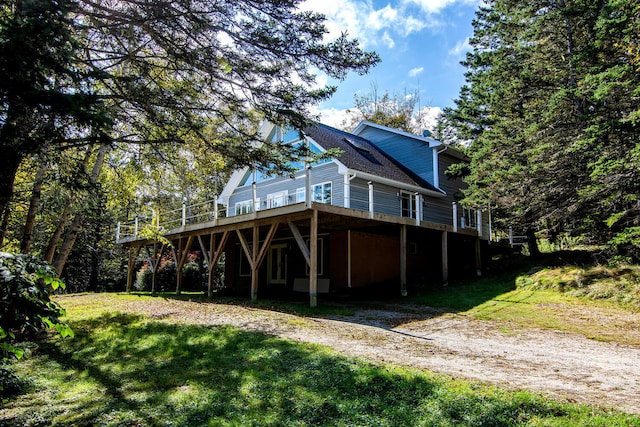 back of house featuring a lawn and a deck