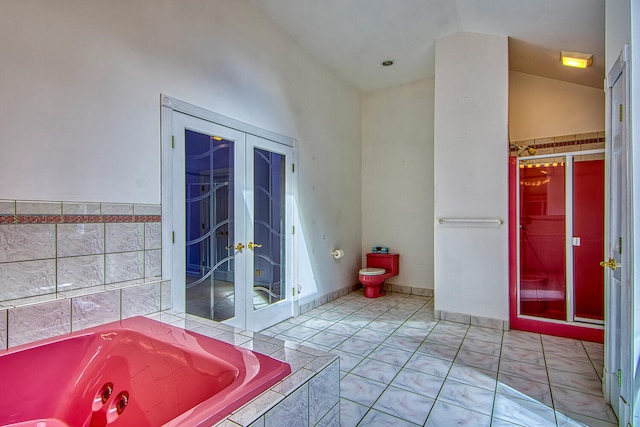 bathroom with tile patterned flooring, high vaulted ceiling, a relaxing tiled tub, french doors, and toilet