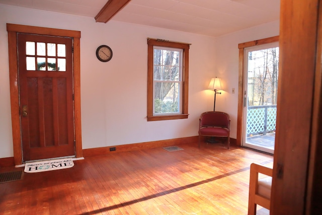 entrance foyer featuring beam ceiling and light wood-type flooring