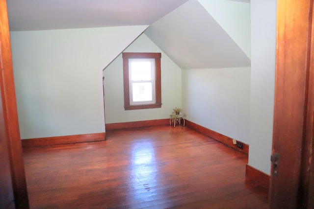 additional living space featuring lofted ceiling and dark hardwood / wood-style flooring