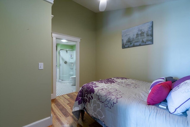 bedroom with hardwood / wood-style floors, ceiling fan, and ensuite bathroom