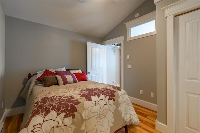 bedroom featuring a closet, lofted ceiling, and light hardwood / wood-style floors