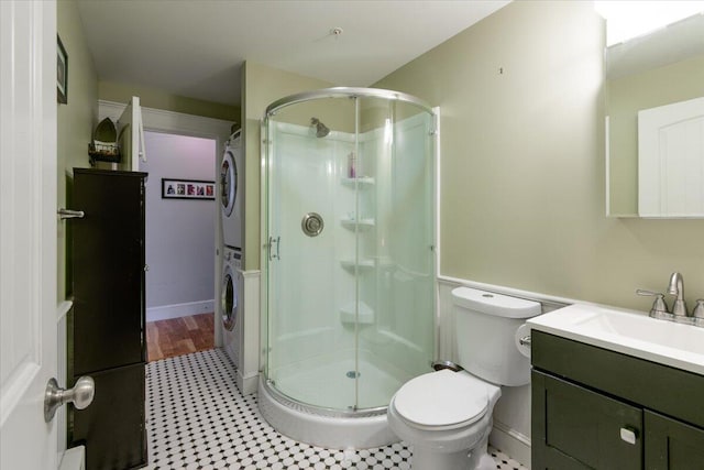 bathroom with stacked washer / dryer, vanity, toilet, and an enclosed shower