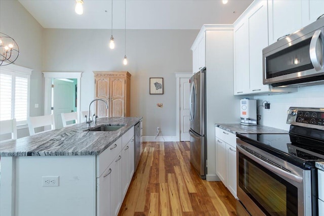 kitchen featuring pendant lighting, appliances with stainless steel finishes, and white cabinets