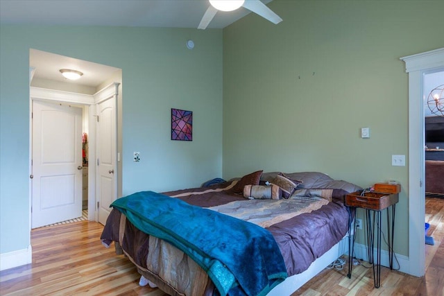 bedroom with light wood-type flooring, lofted ceiling, and ceiling fan