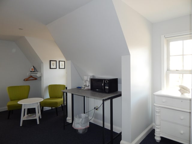 carpeted home office with lofted ceiling