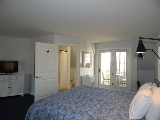 bedroom with dark colored carpet, access to exterior, and ensuite bathroom