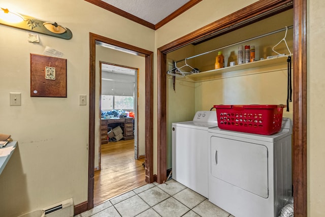 laundry room with ornamental molding, a textured ceiling, washing machine and dryer, a baseboard radiator, and light hardwood / wood-style floors