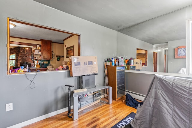 interior space with a baseboard heating unit and hardwood / wood-style floors