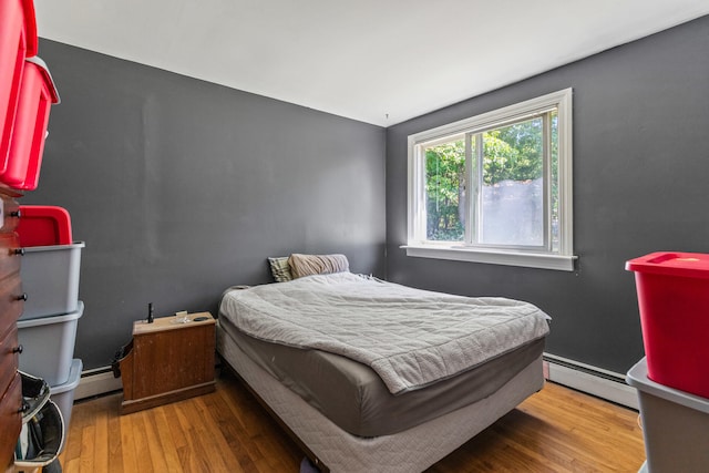 bedroom featuring a baseboard radiator and hardwood / wood-style floors