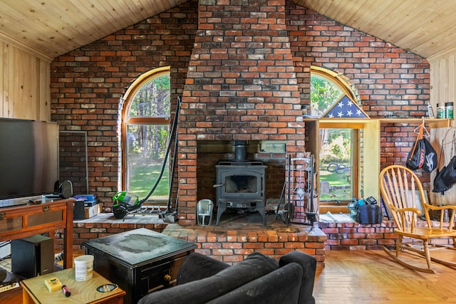 living room with a wood stove, brick wall, and plenty of natural light