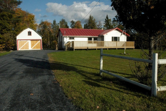 exterior space featuring a front yard, a deck, and a storage shed