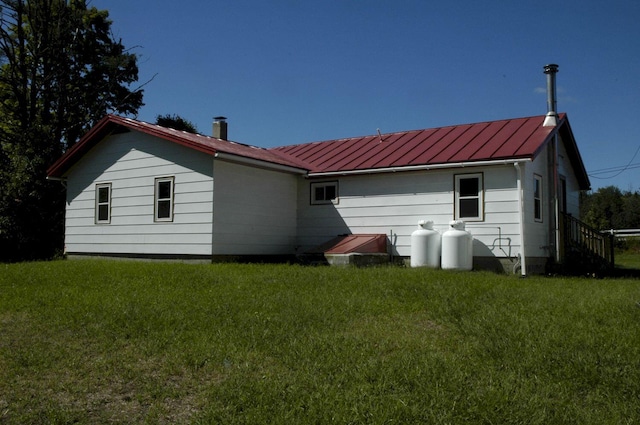 rear view of house featuring a lawn