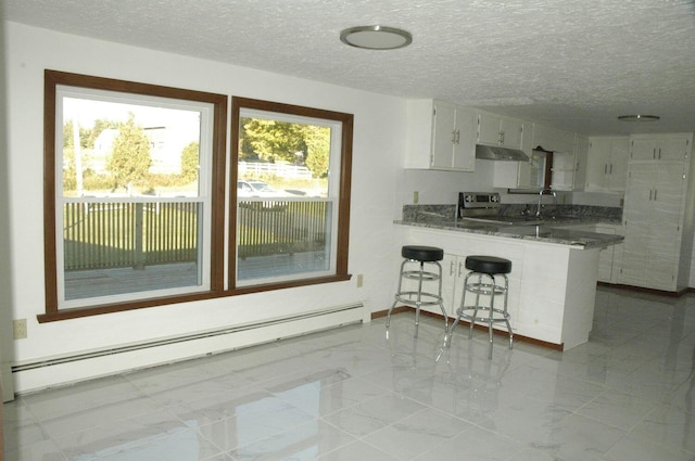 kitchen with dark stone countertops, white cabinetry, kitchen peninsula, a textured ceiling, and a baseboard heating unit