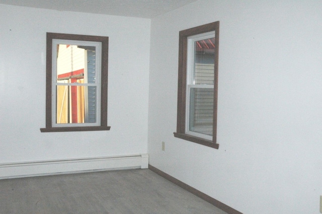 carpeted spare room featuring baseboard heating