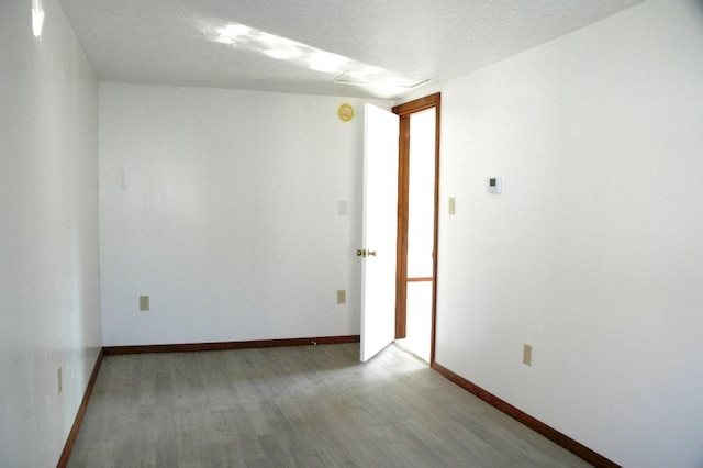 empty room with a textured ceiling and hardwood / wood-style flooring