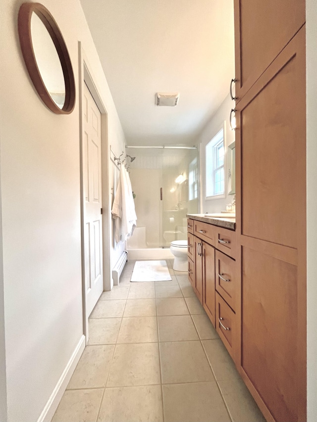 bathroom with tile patterned floors, vanity, a shower with door, and toilet