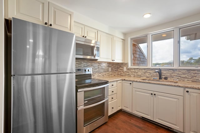 143 Beach Ave Unit 203, Kennebunk, ME 04043 - kitchen featuring appliances with stainless steel finishes, a sink, backsplash, dark wood-style floors, and light stone countertops