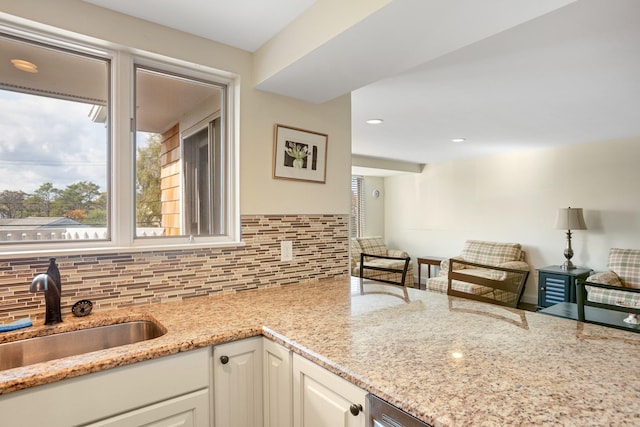 143 Beach Ave Unit 203, Kennebunk, ME 04043 - kitchen featuring a sink, light stone countertops, backsplash, white cabinetry, and open floor plan