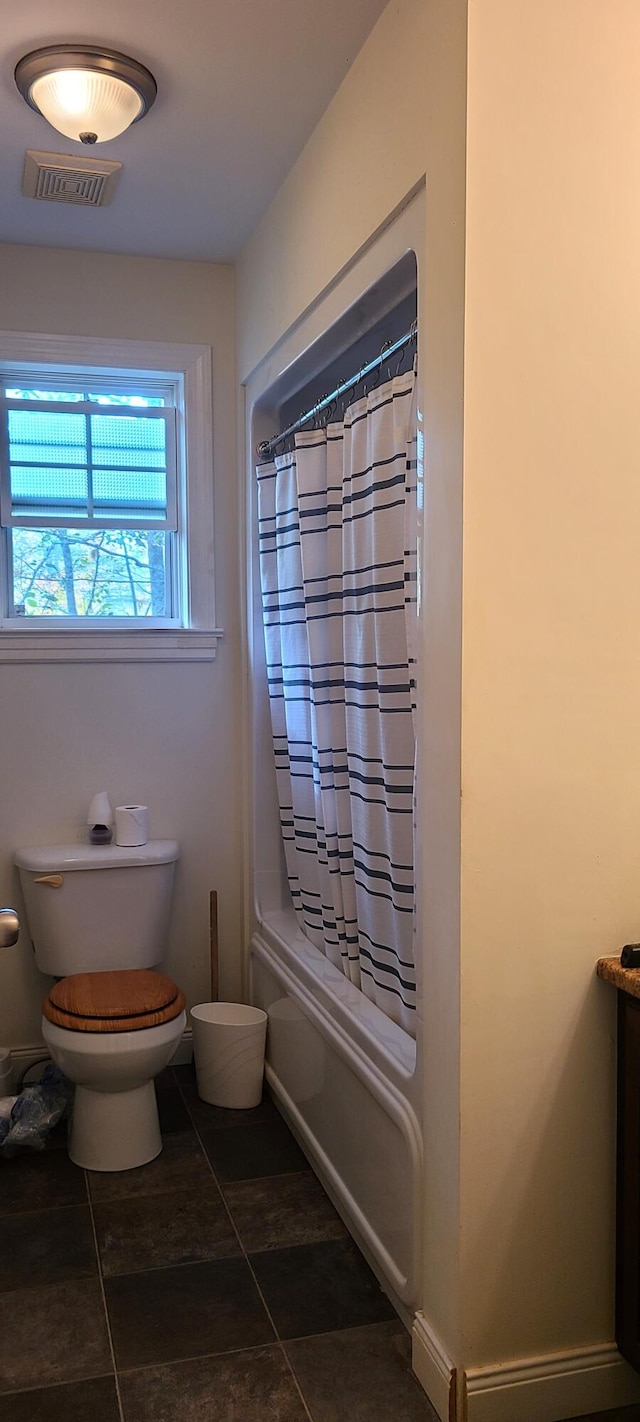 bathroom featuring toilet, baseboards, visible vents, tile patterned floors, and shower / bathtub combination with curtain