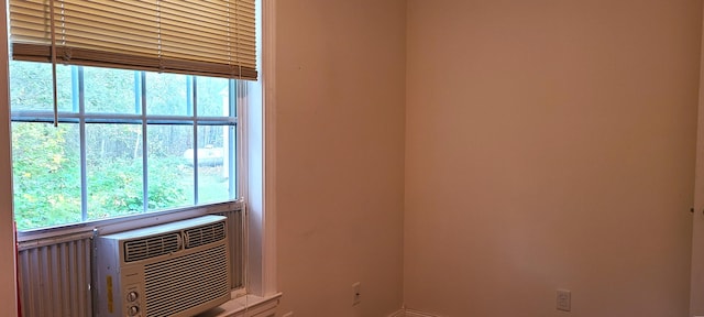 spare room with baseboards and cooling unit