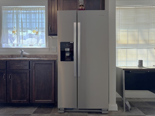 kitchen featuring a sink, stainless steel fridge, and dark brown cabinets