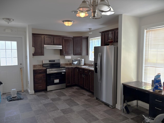 kitchen with under cabinet range hood, a sink, dark brown cabinetry, a chandelier, and appliances with stainless steel finishes