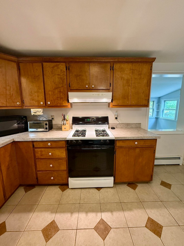 kitchen featuring a baseboard radiator, light tile patterned floors, and white stove