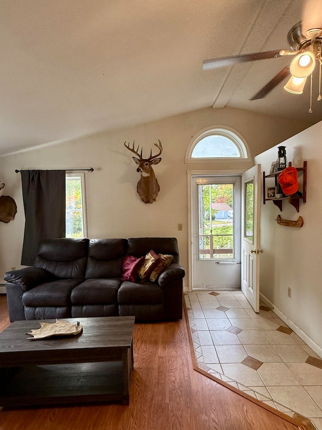 living room with wood-type flooring, vaulted ceiling, and ceiling fan