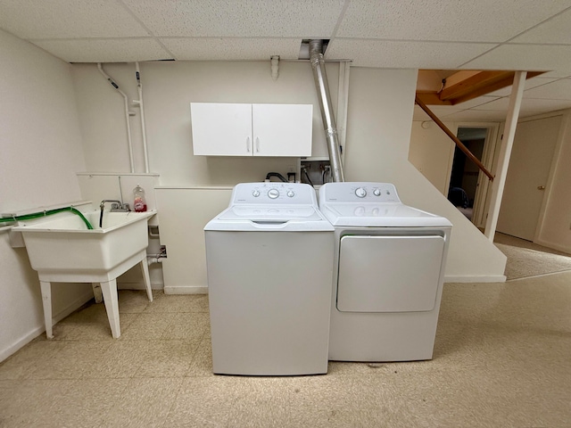 clothes washing area featuring cabinets and washing machine and dryer