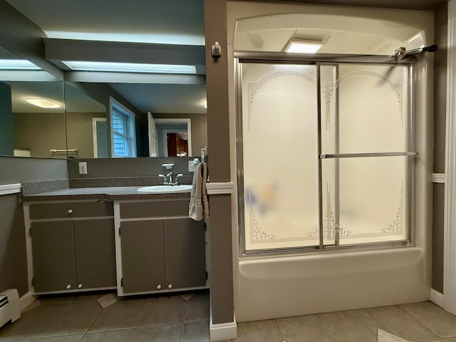 bathroom with bath / shower combo with glass door, vanity, tile patterned flooring, and a baseboard heating unit