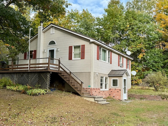 rear view of house with a deck and a lawn