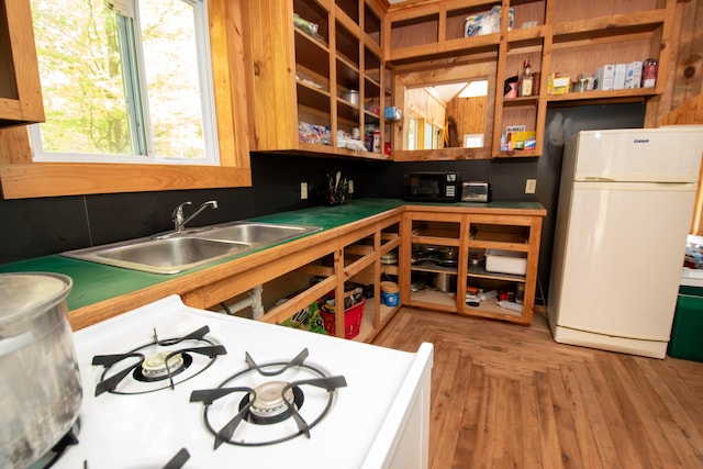 kitchen featuring parquet flooring, white refrigerator, and sink