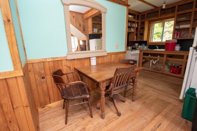 dining area with wooden walls and light hardwood / wood-style floors