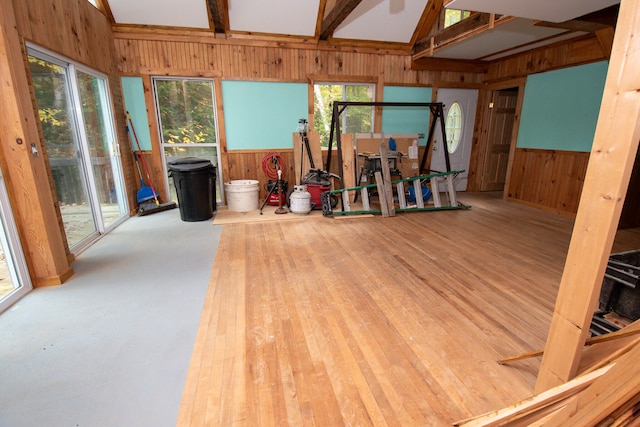 miscellaneous room with hardwood / wood-style flooring, wood walls, and lofted ceiling with beams