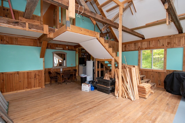 miscellaneous room with beam ceiling, wood-type flooring, wood walls, and high vaulted ceiling